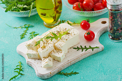 Zdjęcie XXL Ser feta, pomidory cherry i rukola na stole. Składniki na sałatkę.