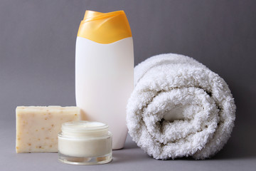 Shower accessories on a colored background. Towel, soap, cream, shower gel, shampoo. means for body care.