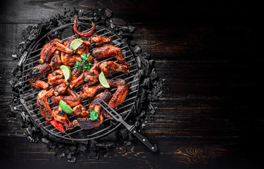 chicken wings of barbecue in honey sauce with lime slices. the dish is made and served in a rustic style