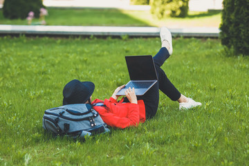 Happy hipster young woman working on laptop outdors. Student girl using laptop in university campus. Toned image.