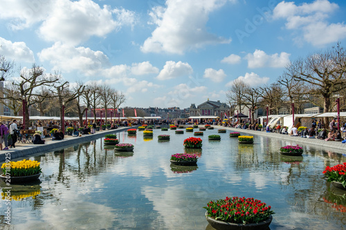 Plakat AMSTERDAM holandie - APR 2, 2017: Piękny muzeum kwadrat z stawowym i spławowymi tulipanami. Hala muzyczna w tle