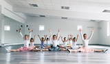 Choreographed dance by a group of beautiful young ballerinas practicing during class at a classical ballet school.