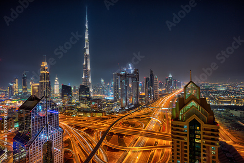 Фото: Dubai skyline during night with amazing city center lights and Sheikh Zayed road traffic,United Arab Emirates. Dubai skyline during night with amazing city center lights and Sheikh Zayed road traffic,United Arab Emirates.