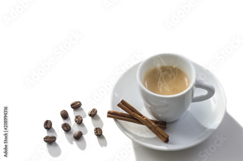 Фото: White steamy cup near cinnamon sticks in coffee beans, whitebackground White steamy cup near cinnamon sticks in coffee beans, whitebackground