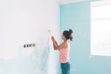 Child painting a wall in room