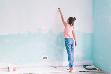 Child painting a wall in room