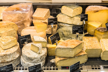 Different cheeses on display in a French supermarket. Paris, France