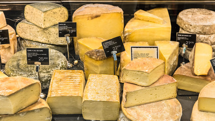 Different cheeses on display in a French supermarket. Paris, France