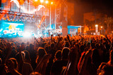 View of a concert with people or audience with hands in the air and clapping at a music festival. Summer music festival.