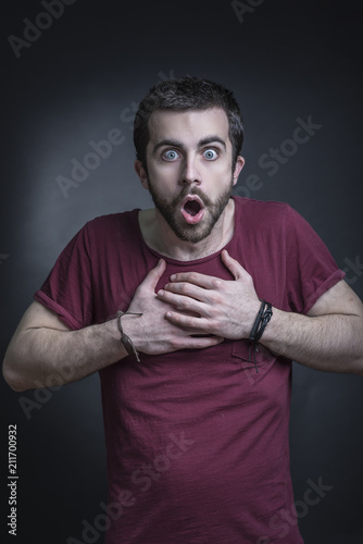Фото: Shocked and appalled young man expression, studio, black background Shocked and appalled young man expression, studio, black background