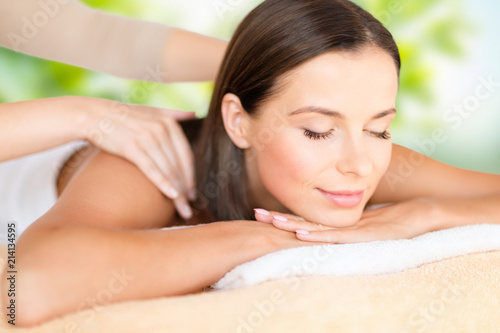 wellness, spa and beauty concept - close up of beautiful woman having massage over green natural background wellness, spa and beauty concept - close up of beautiful woman having massage over green natural background