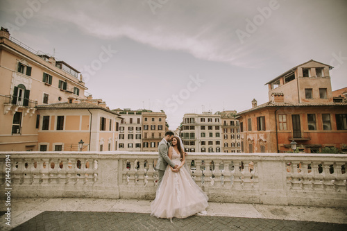 Young newly married couple posing in Rome with beautiful and ancient architecture in the background Young newly married couple posing in Rome with beautiful and ancient architecture in the background