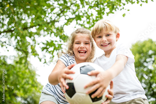 Geschwister spielen mit einem Fußball Geschwister spielen mit einem Fußball