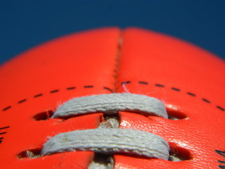 Close up of an Australian rules football on a blue sky background
