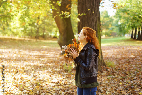 Foto obraz na płótnie canvas jednoczęściowy - Young happy woman playing with leaves in park