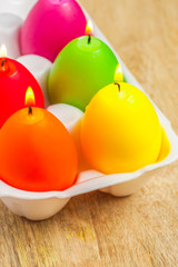 Set of colored Easter egg candles in an egg box