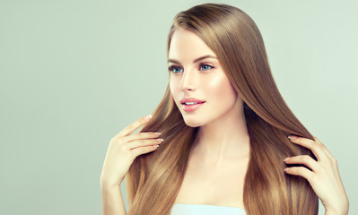Beautiful model girl with shiny blonde straight long hair . Care and hair products . 
