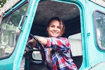 Young beautiful girl working on a tractor in the field, unusual work for women, gender equality concept