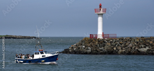 Zdjęcie XXL Latarnia morska przy schronieniem Howth przed iskrzastym niebieskim niebem i łódź w przedpolu