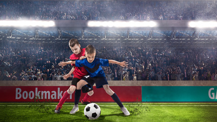 two kids fotball players struggling for the ball