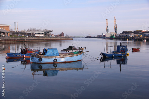 Plakat Małe łodzie rybackie w Port of Sunderland na rzece Wear rzucają swoje odbicie na spokojne wody