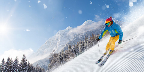 Skier skiing downhill in high mountains