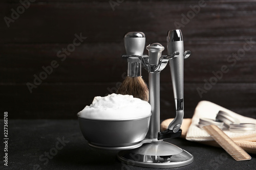 Shaving accessories on table against dark background with space for text © New Africa