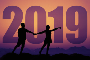 Silhouette of a couple in love at sunset with new year 2019