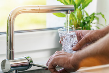 Filling glass of water from stainless steel kitchen faucet