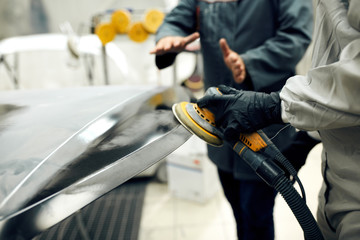 close up, Auto mechanic grinds car part for painting. Car body work auto repair paint after accident