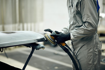 mechanic worker repairman sanding polishing car and preparing automobile for painting