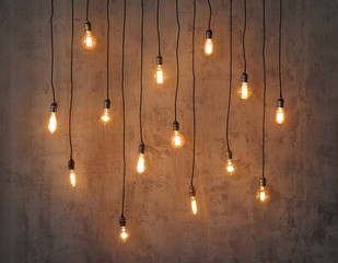 Edison light bulb background. Vintage lamps over concrete background.