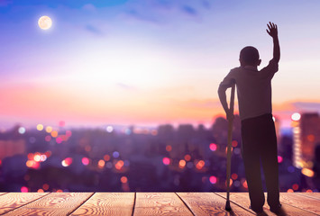 International Day of Persons with Disabilities concept? Silhouette a disabled man standing at mountain city background