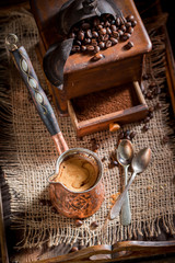 Freshly milled coffee, old grinder and pot boiled coffee