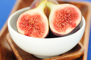 Close-up of raw figs in wooden bowl
