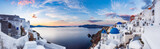 Beautiful panorama view of Santorini island in Greece at sunrise with dramatic sky.