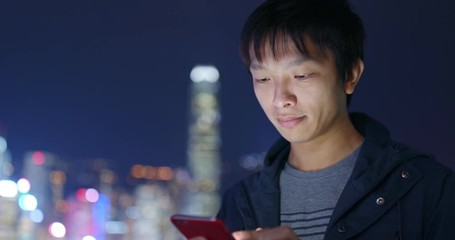 Asian man use of cellphone at night