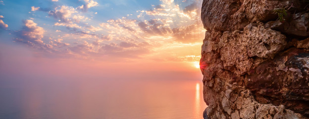 View of sunset on sea view through window in fortress with reflection on stones and shape sun rays clouds. Holiday vacation travel seascape Toned landscape wide angle