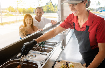 People standing in line in front of food truck waiting for their meal 