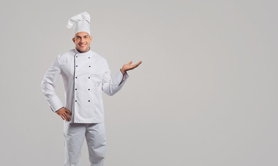 Chef in a white uniform makes a gesture.