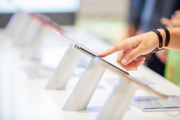 close up hand choosing a new mobile or smart phone in a shop