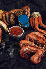 Set of fresh seafood: red and black caviar, limb of hairy crab, limb of snow crab, far eastern kamchatka crab
