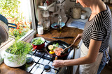 Woman cooking salmon in a pan