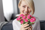 Cheerful woman with cute roses looking away