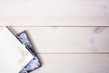 Gift box with bow on wooden background