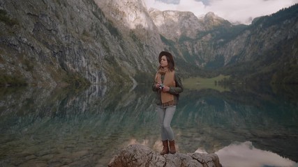 Attractive photographer with a retro camera by the lake