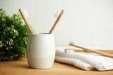 The bamboo toothbrushes in a gray glass with copy space in bathroom