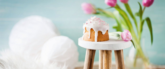 Kleiner Kuchen auf Hocker mit frühlingshaft, dekorativem Hintergrund im Banner / Header Format / Geburtstag, Valentinstag, Muttertag