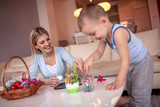 Mother and her son painting colorful Easter eggs