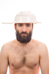 Bearded, funny, young man with a colander on his head, white background, body